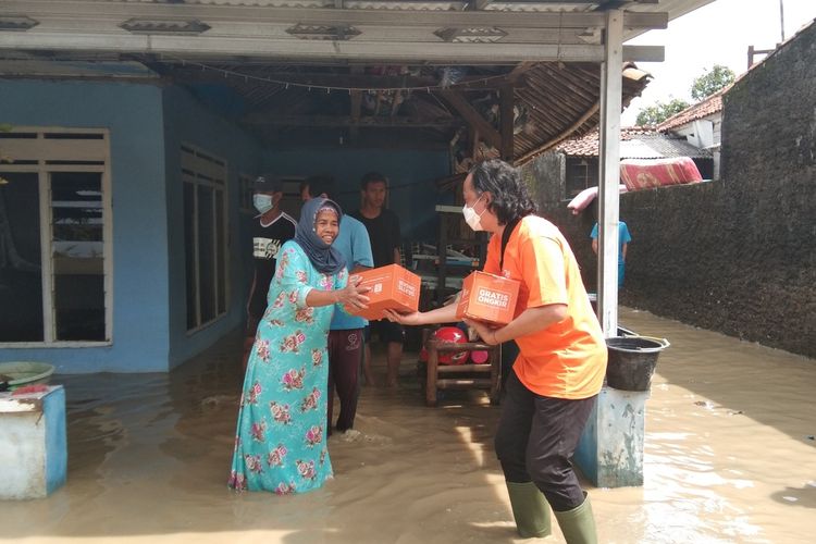 Seorang warga Desa Karangligar, Kecamatan Telukjambe Barat, Kabupaten Karawang, yang tengah membersihkan rumah menerima bantuan dari Shopee, Jumat (12/2/2021).