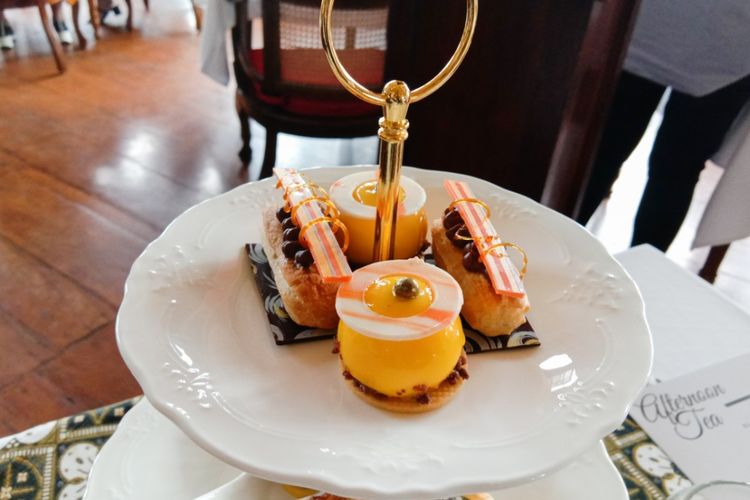 Hidangan dalam menu baru Cafe Batavia bernama Afternoon Tea. Hidangan terdiri dari Cremeux eclair caraibe (kanan dan kiri) dan Mango passion jelly dome (tengah), Jakarta, Jumat (28/2/2020).