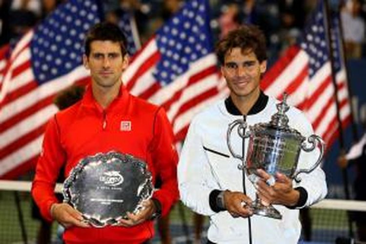 Petenis Spanyol, Rafael Nadal (kanan) memegang trofi juara US Open, berdiri di samping Novak Djokovic dari Serbia, yang  keluar sebagai runner-up. Mereka bertemu di partai final US Open yang berlangsung di USTA Billie Jean King National Tennis Center, New York, Senin (9/9/2013).