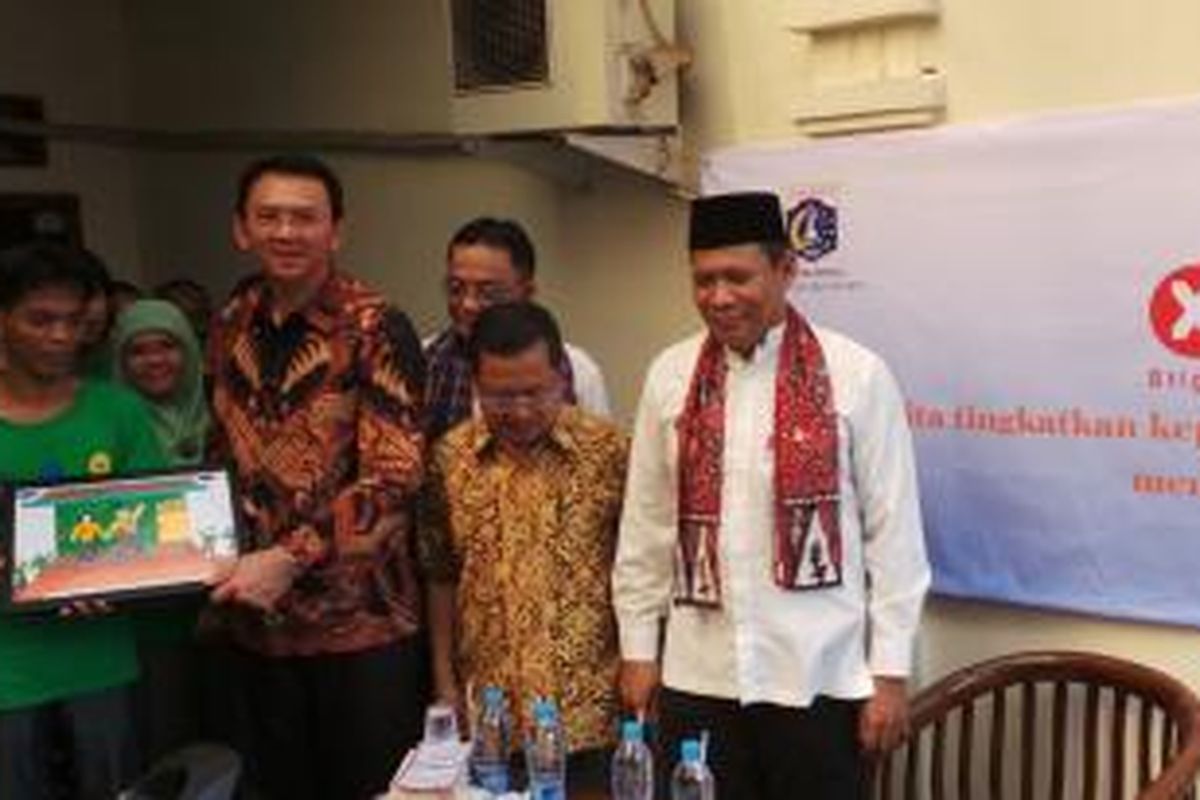 Basuki Tjahaja Purnama tampak sumringah menerima sebuah lukisan dari Ihsan, salah seorang ODMK (orang dengan masalah kejiwaan).