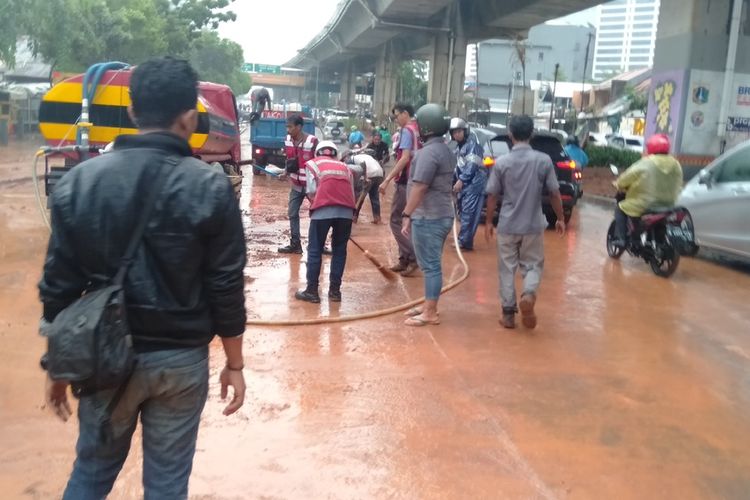 anggota PPSU kelurahan Semanggi dan pihak pengerjaan proyek bersihkan sisa lumpur akibat banjir di Jalan Dr Satrio, Kuningan, Jakarta Selatan, Selasa (17/12/2019)