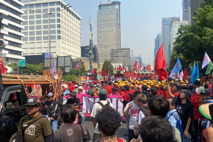 Ribuan massa buruh berkumpul di Jalan MH Thamrin dan mengunjuk rasa pencabutan UU Ciptaker, UU Kesehatan, UU P2SK, dan mewujudkan JS3H, Kamis (10/8/2023). (KOMPAS.com/XENA OLIVIA)