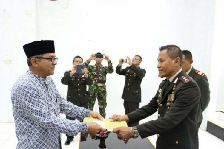 Kapolres Aceh Utara AKBP Untung Sangaji menyerahkan surat tanah untuk Teuku Ramli, cucu dari pahlawan nasional Cut Meutia, di Mapolres Aceh Utara, 10 November 2017.