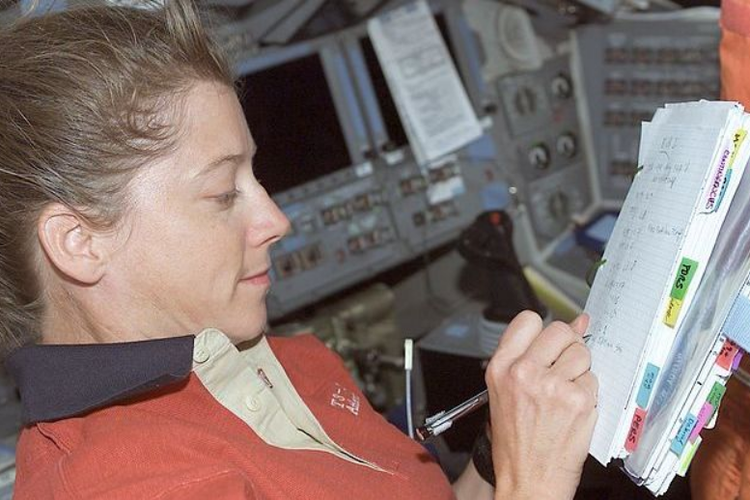 Astronot NASA Pamela Melroy menulis catatan dengan pena luar angkasa. Pensil tidak digunakan dalam aktivitas mencatat oleh para astronot selama menjalankan misi luar angkasa.