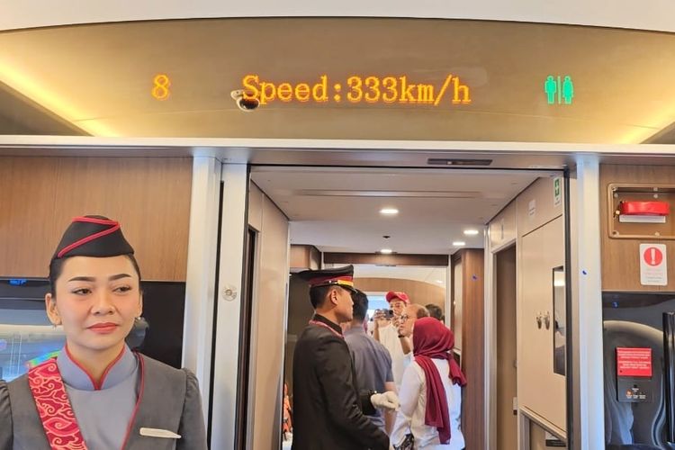 Suasana di dalam gerbong kereta cepat Jakarta-Bandung, dengan layar pengumuman kecepatan kereta. 
