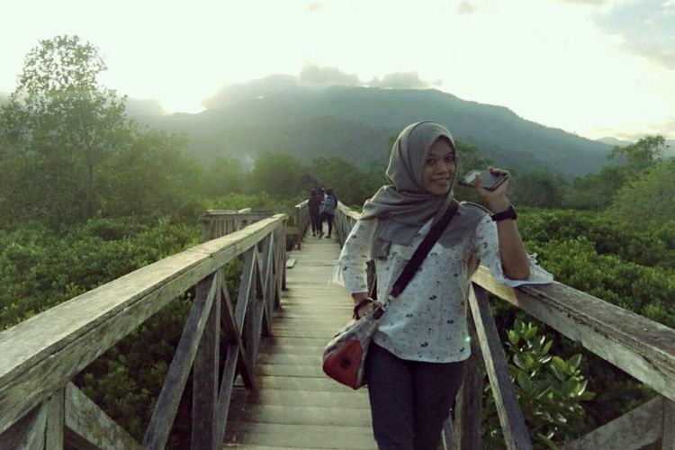 Pengunjung berfoto di Jembatan Galau di kawasan wisata mangrove Cengkrong, Kabupaten Trenggalek. Kawasan hutan bakau ini ramai dikunjungi wisatawan, khususnya saat hari libur.