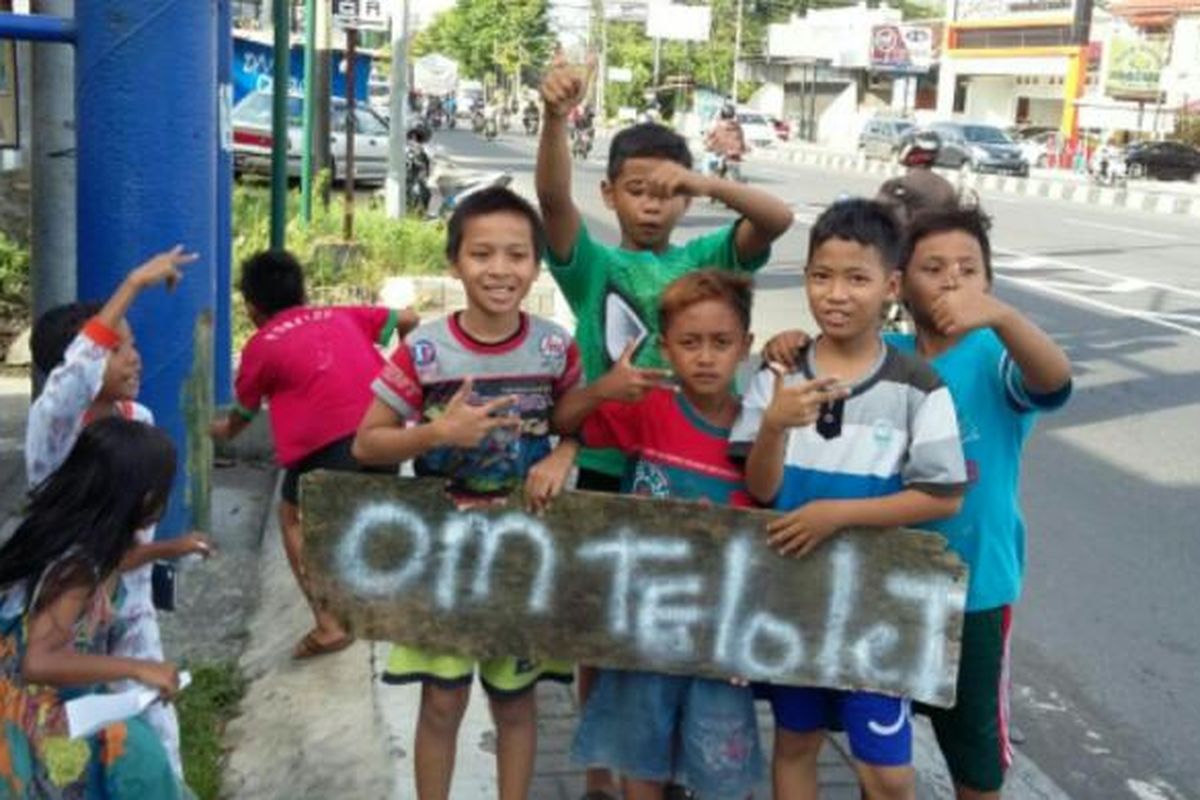 Anak-anak kecil membawa papan bertuliskan Om telolet saat didekat terminal Jombor, Sleman