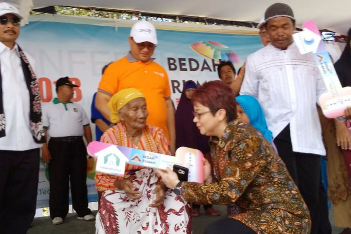 Theresia Rustandi, Sekretaris Perusahaan dan Kepala CSR PT Intiland Properti Tbk menyerahkan bantuan kepada Tura (85 thn), salah satu warga Sungailiat, Bangka Belitung, Jumat (13/4/2018). Bantuan tersebut diberikan melalui program Intiland Teduh pada Bedah Rumah HUT REI ke-46.