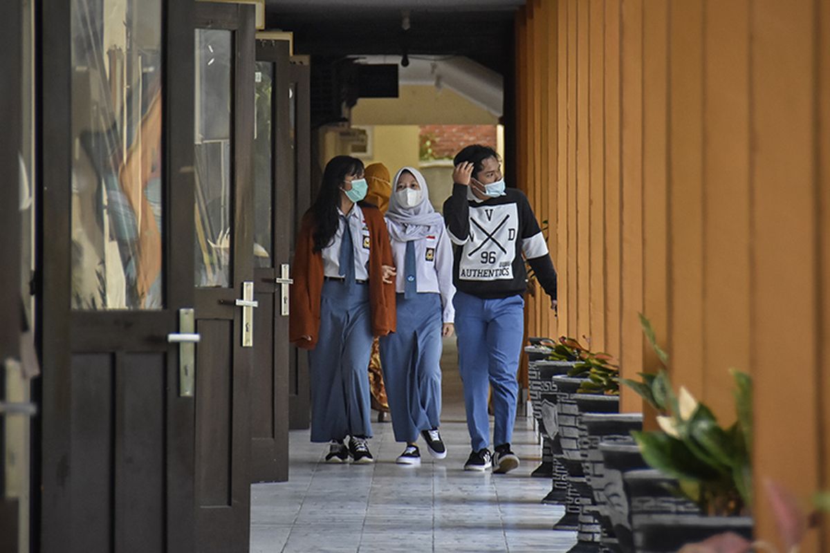 Sejumlah siswa berjalan menuju kelasnya saat hari pertama masuk sekolah pembelajaran tatap muka di SMAN 1 Mataram, NTB, Senin (4/1/2021). Pembelajaran secara tatap muka terbatas di tengah pandemi Covid-19 pada semester genap tahun ajaran 2020/2021 mulai dilaksanakan di wilayah NTB pada Senin (4/1) di sejumlah sekolah jenjang SMA, SMK dan SLB dengan menerapkan protokol kesehatan yang ketat.