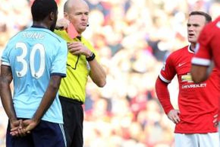 Wasit Lee Mason (kuning) memberikan kartu merah kepada striker Manchester United, Wayne Rooney, pada laga melawan West Ham United di Old Trafford, Manchester, Sabtu (27/9/2014).