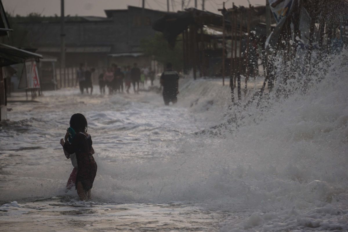 Sejumlah warga berjalan menghindari gelombang air laut di Pesisir pantai Utara, Pekalongan, Jawa Tengah, Senin (23/5/2022). Palang Merah Indonesia (PMI) Kota Pekalongan menghimbau warga sekitar pesisir pantai Utara Pekalongan untuk waspada dengan adanya gelombang laut setinggi sekitar 1-3 meter dan dapat menyebabkan banjir rob.