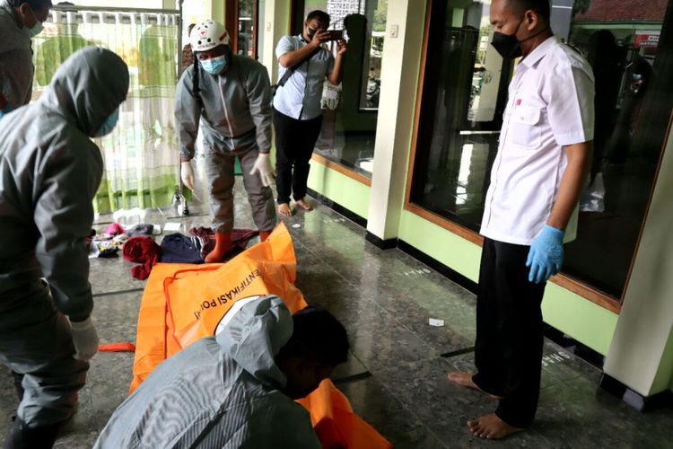 Petugas memasukkan jasad Tjipto Suroso ke kantong mayat di teras sebuah masjid di Jalan Ahmad Yani, Kota Blitar, Kamis (10/2/2022)