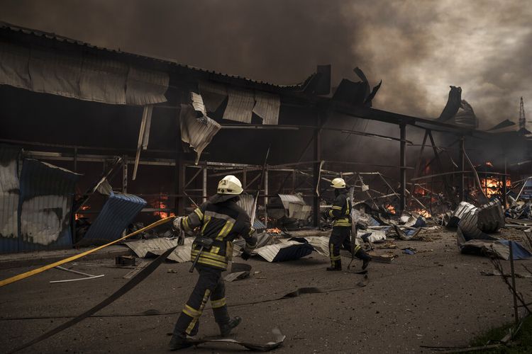 Petugas pemadam kebakaran bekerja memadamkan api di gudang di tengah pemboman Rusia di Kharkiv, Ukraina, Sabtu, 23 April 2022.