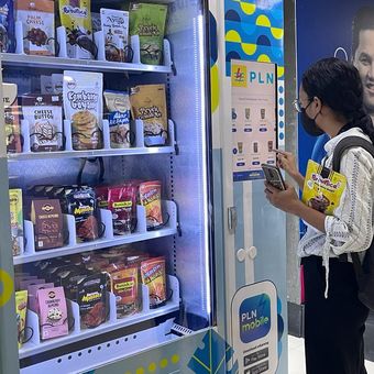 Seorang penumpang kereta membeli produk cemilan dari vending machine di Stasiun Gambir, Jakarta, Senin (22/1/2024). 