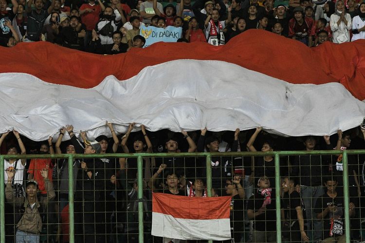 Sejumlah suporter tim sepak bola timnas U19 Indonesia memberikan dukungan dengan membentangkan bendera Merah Putih pada laga lanjutan Grup A Piala AFF U19 2022 melawan Filipina Stadion Patriot Chandrabhaga, Bekasi, Jawa Barat, Jumat (8/7/2022). Indonesia menang dengan skor 5-1. ANTARA FOTO/ Fakhri Hermansyah.