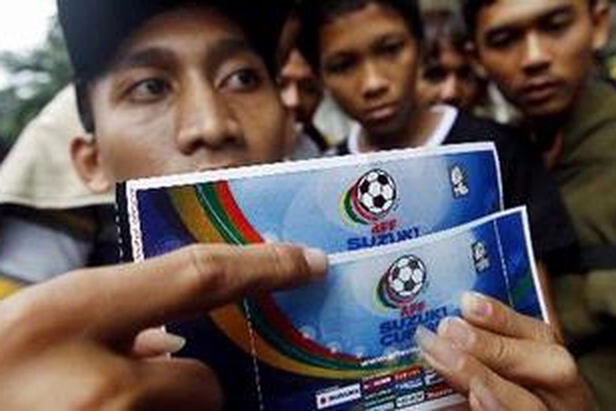 Rahmad menunjukkan dua tiket final leg kedua Piala AFF 2010 di Stadion Gelora Bung Karno, Jakarta Pusat, Selasa (28/12/2010). Satu tiket (bawah) yang dibelinya dari calo diduga palsu. Keberadaan tiket palsu ini membuat calon penonton resah.