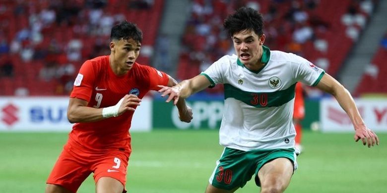 Pemain timnas Singapura, Ikhsan Fandi, berduel dengan bek Indonesia, Elkan Baggott, dalam laga leg pertama semifinal Piala AFF 2020. Laga timnas Singapura vs Indonesia digelar di National Stadium Singapura pada 22 Desember 2021.