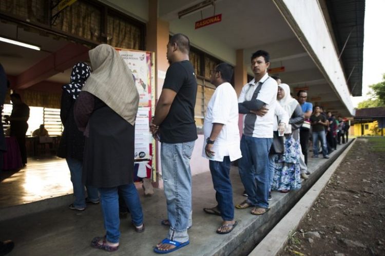 Penduduk Malaysia antre untuk memberikan suara mereka di tempat pemungutan suara selama pemilihan umum ke-14 di Alor Setar, Rabu (9/5/2018). (AFP/Permata Samad)