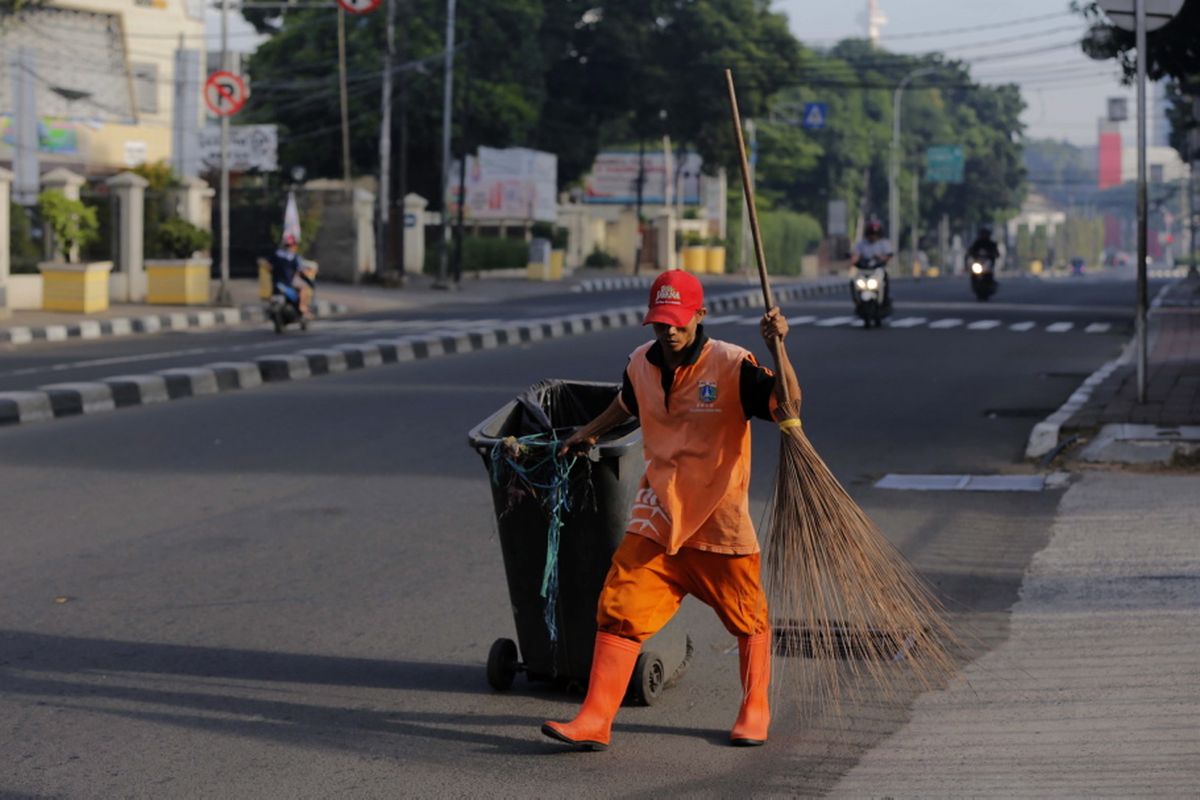 Pasukan Oranye saat membersihkan ruas jalan di jalan Menteng Raya, Jakarta Pusat, Minggu (25/6/2017). Hari Raya Idul Fitri 1438 H, kondisi jalan di Jakarta terpantau lengang.