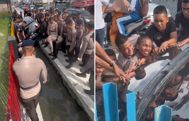 Tangkapan layar unggahan video yang memperlihatkan sejumlah anggota Brimob gotong royong mengevakuasi mobil yang masuk parit.