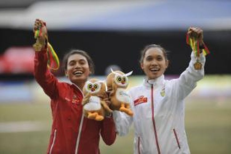 Pelompat jauh Maria Londa dan pelari Rini Budiarti memamerkan emas SEA Games 2013 di lintasan atletik Wunna Theikdi, Naypyitaw, Myanmar, Rabu (18/12/2013). Lompatan terjauh Maria Londa dan catatan waktu tercepat Rini Budiarti menjadi penghapus dahaga ditengah paceklik sumbangan tim atletik bagi kontingen Indonesia.
