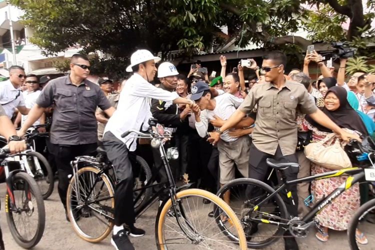 Sepeda onthel Jokowi oleng saat warga berebut salaman di alun-alun Pasar Johar Semarang, Senin (30/12/2019)