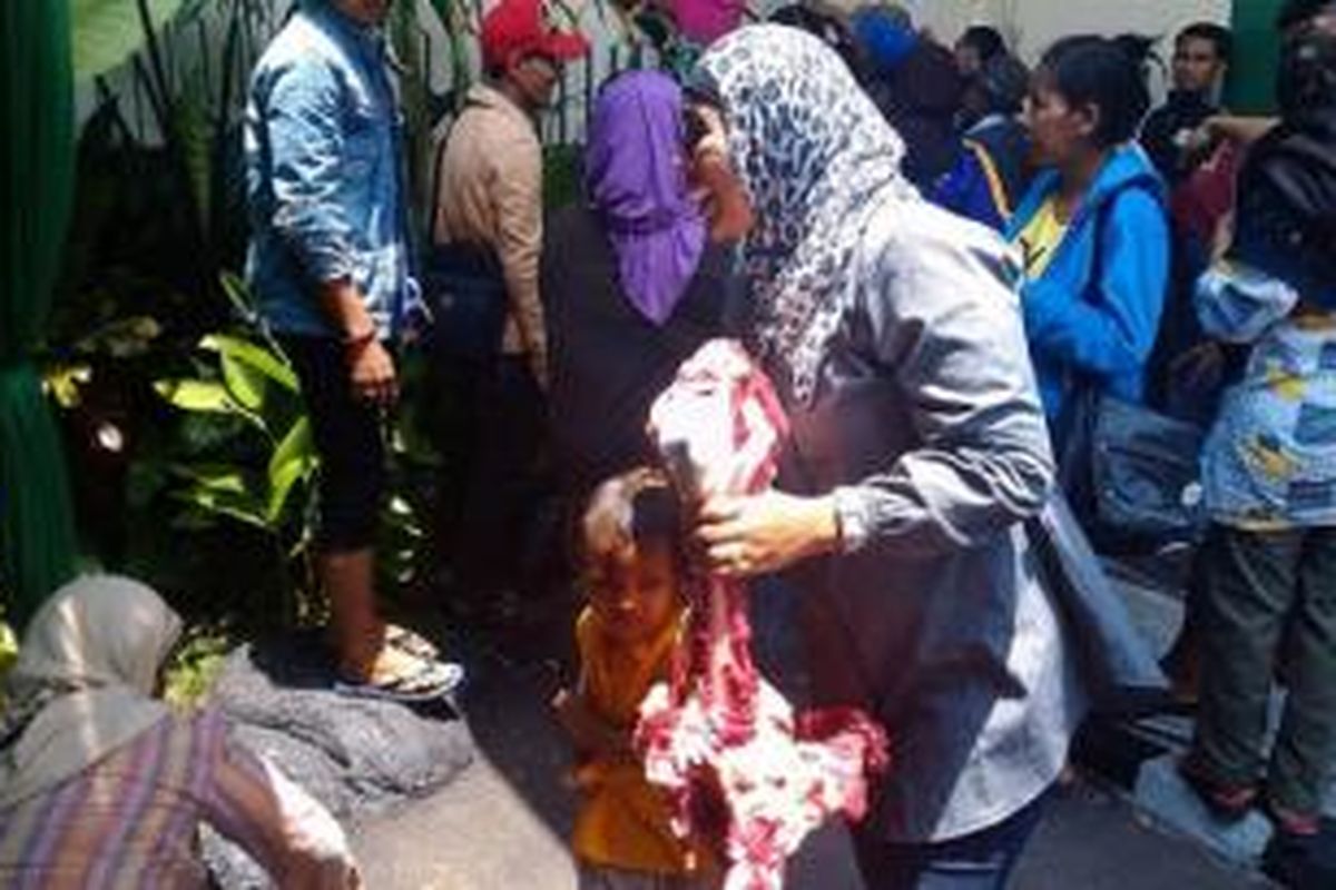 Seorang ibu berhasil menggondol tulang sapi dari Masjid Baitul Adli di Kejaksaan Agung, Minggu (5/10/2014). Sempat juga terjadi aksi dobrak pagar. 