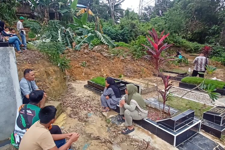 Keluarga dan ahli waris makam tengah menunggu proses pembersihan tanah longsor yang menimpa puluhan makam di TPU Sei Panas, Jumat (21/6/2024)