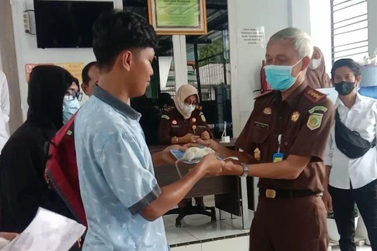 Pengunjuk rasa memberikan seekor Tikus putih kepada Kajari Kota Palopo, sebagai simbol bahwa Kota Palopo syarat dengan kasus korupsi yang pelakunya bebas berkeliaran dan segera harus diringkus, Senin (21/3/2022)