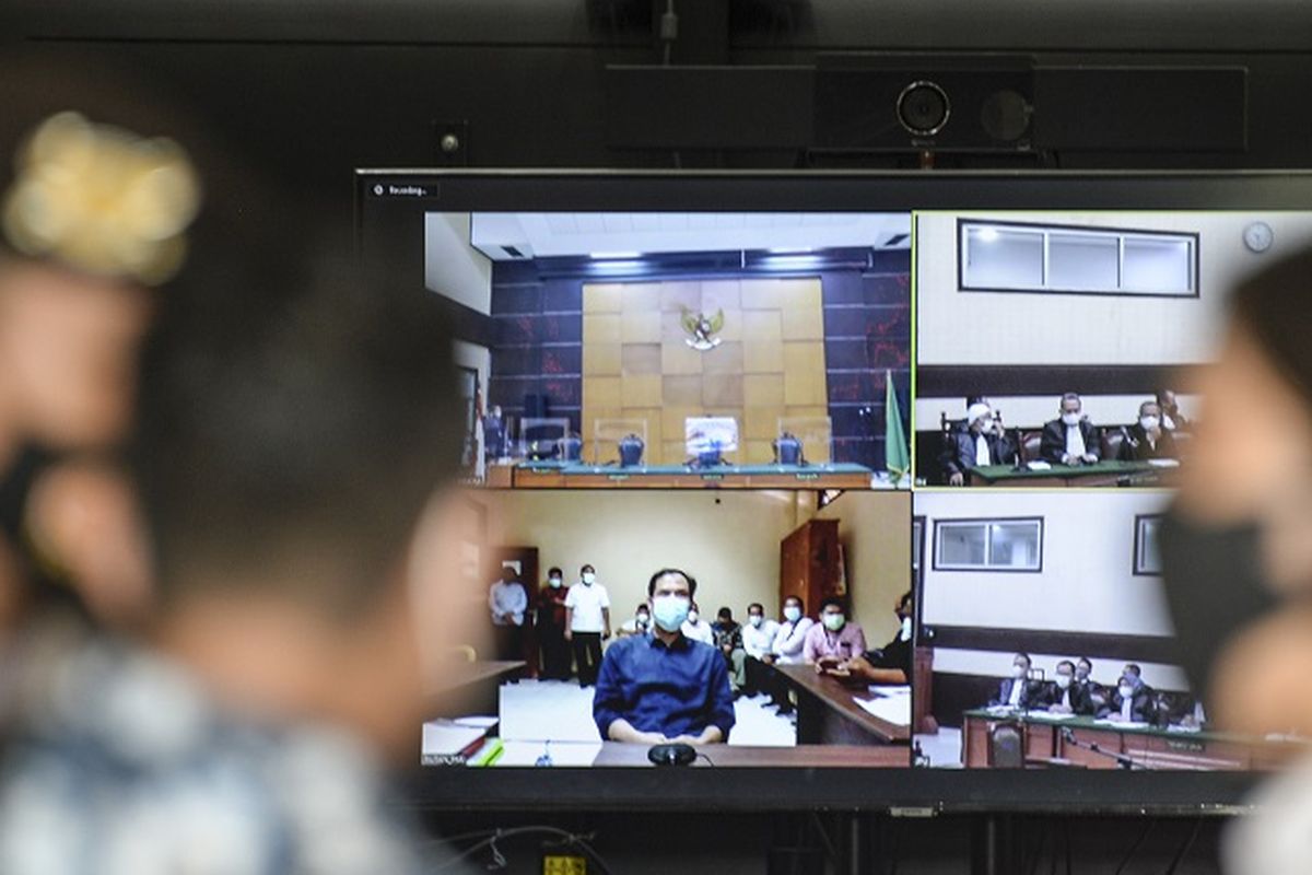 Layar televisi menampilkan jalannya sidang perdana kasus dugaan terorisme dengan terdakwa Munarman yang berjalan secara daring di Pengadilan Negeri Jakarta Timur, Rabu (1/12/2021). Sidang perdana yang berjalan secara daring tersebut beragendakan pembacaan dakwaan dari Jaksa Penuntut Umum. ANTARA FOTO/M Risyal Hidayat/foc.
