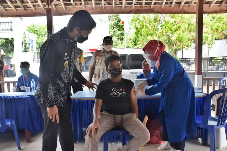  DIVAKSIN—Bupati Madiun, Ahmad Dawami mentyaksikan slah satu anak mendapatkan vaksinasi covid-19 di Desa Joho, Kecamatan Dagangan, Kabupaten Madiun, Jawa Timur, Kamis (22/7/2021).