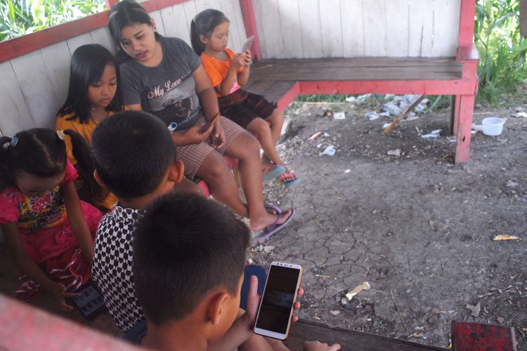 Sejumlah pelajar Sekolah Dasar (SD) ditemani salah seorang wali murid mencari sinyal internet di sebuah gubuk di puncak perbukitan, di Desa Suwatu, Kecamatan Gabus, Kabupaten Grobogan, Jawa Tengah, Selasa (2/6/2020) pagi.