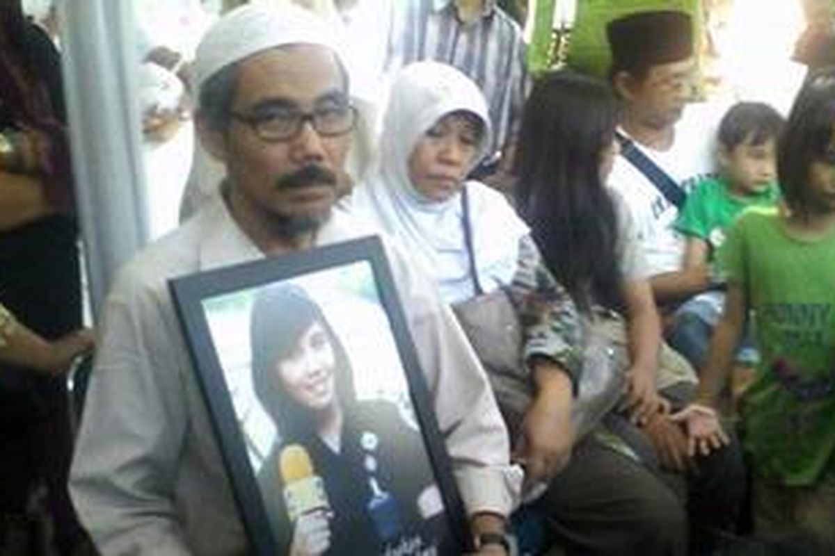 Ayah Ismi, SUnarto menunjukkan foto Ismiati bertuliskan `Kami relakan yang terbaik Untukmu` di bawah foto Ismi reporter TRANSTV sebelum menyaksikan langusng jenazah Ismi di RS Polri Jakarta Timur, Selasa (22/5/2012)