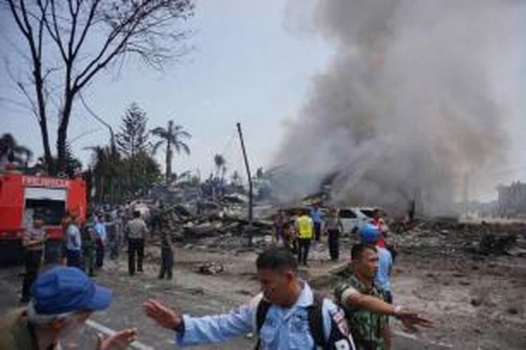 Petugas mengamankan lokasi jatuhnya pesawat hercules C-130 TNI AU di Jalan Jamin Ginting, Medan, Sumatera Utara, 30 Juni 2015. Pesawat itu jatuh dua menit setelah lepas landas dari Pangkalan Udara Soewondo pada pukul 12.08 WIB ketika hendak menuju Tanjung Pinang.