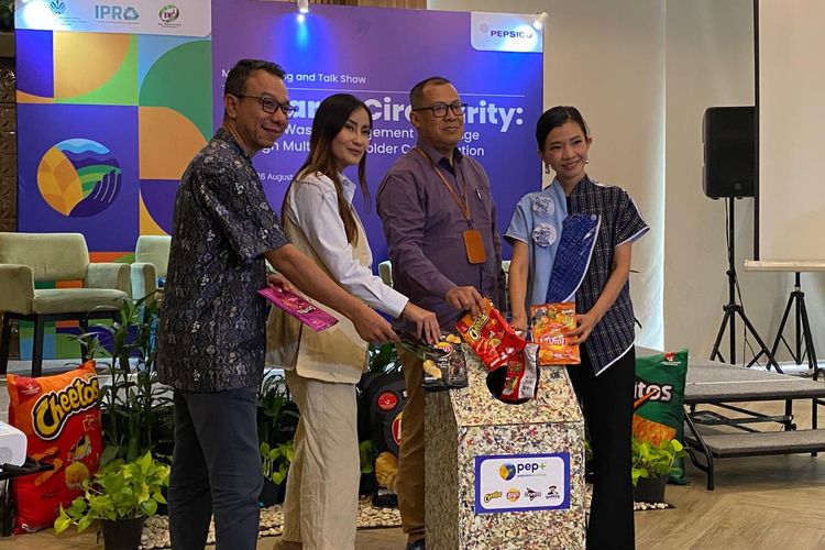 Perwakilan IPRO, PepsiCo Indonesia, dan KLH memasukkan kemasan bekas makanan ringan untuk didaur ulang, di Jakarta Selatan, Selasa (26/8/2025). 