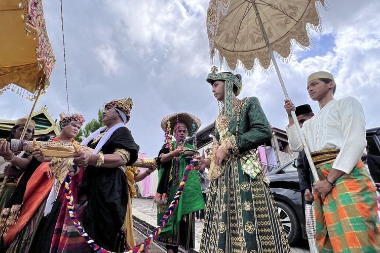 Pemimpin bissu (baju hitam) melakukan penjemputan secara adat calon mempelai laki-laki pada sebuah hajatan pernikahan adat di Soppeng, Sulawesi Selatan, Minggu (17/7/2022).