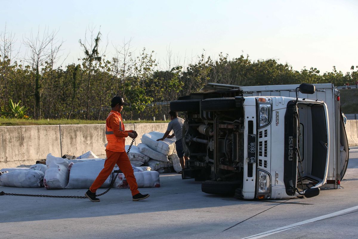 Truk terguling karena mengalami kecelakaan di ruas tol Solo - Ngawi kilometer 555, Ngawi, Jawa Timur, Jumat (24/5/2019). Kecelakaan yang mengakibatkan satu orang luka-luka ini disebabkan pecah ban.