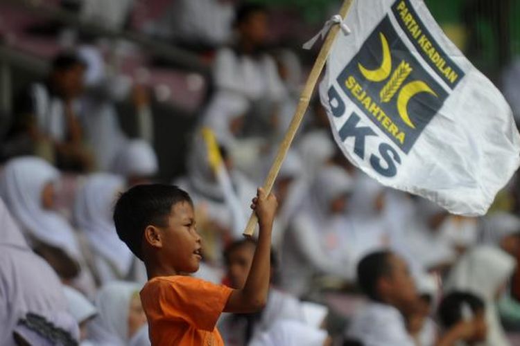 Seorang bocah mengibarkan bendera PKS saat milad Partai Keadilan Sejahtera ke-13, Minggu (17/4/2011), di Stadion Gelora Bung Karno, Jakarta.