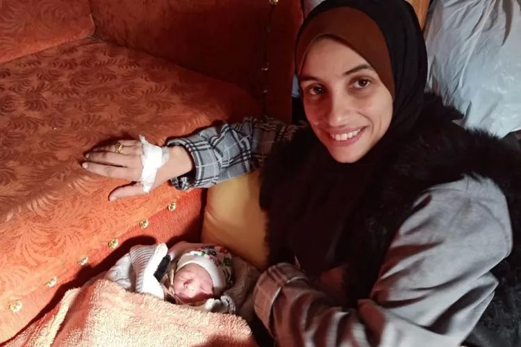Wanita di Palestina bernama Alaa bersama bayi perempuannya yang ia lahirkan di jalan di tengah-tengah perang Israel dan Hamas.