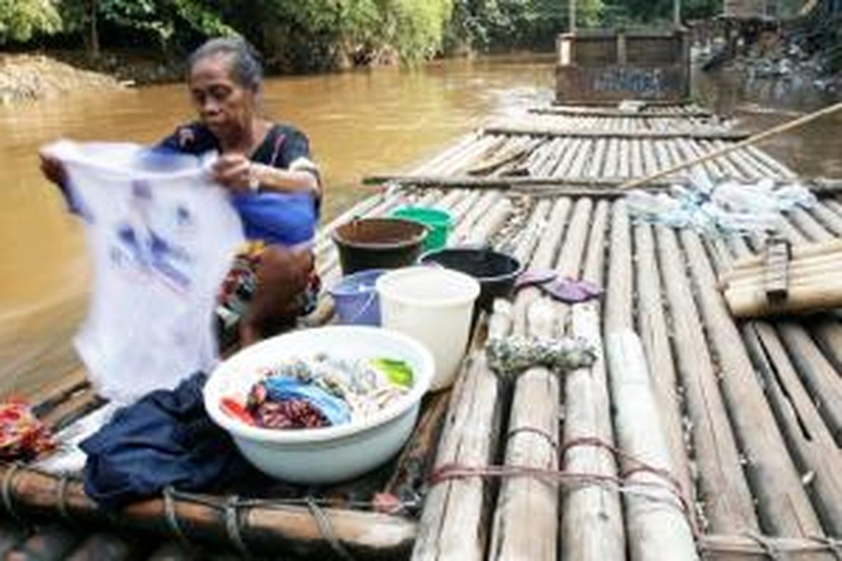 Seorang warga Kebon Pala, Kampung Melayu, Jakarta, mencuci pakaian di aliran Sungai Ciliwung yang keruh dan penuh sampah. Indonesia masih buruk dalam masalah sanitasi dan akses terhadap air bersih. Warga miskin akhirnya mengesampingkan persoalan kebersihan dan kesehatan hidupnya.