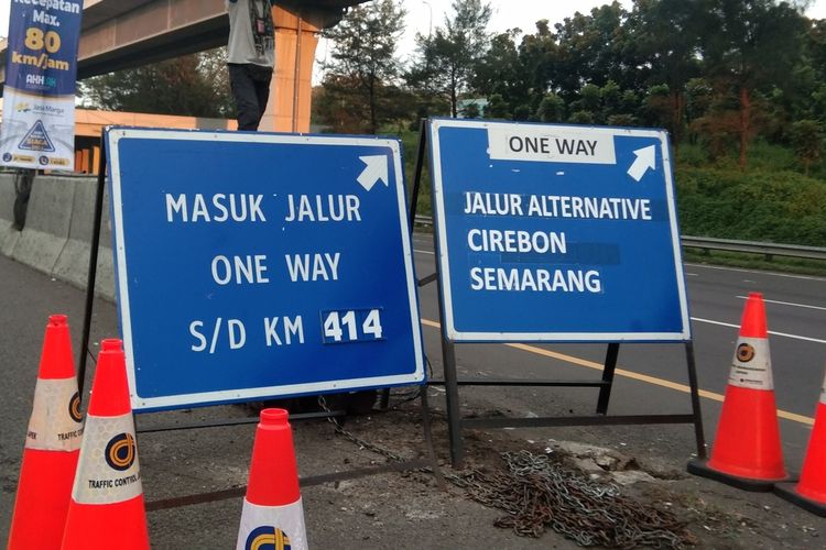 Petugas tengah mengarahkan kendaraan masuk lajur kanan pada penerapan one way di kilometer 47 tol Jakarta-Cikampek, Rabu (28/4/2022).