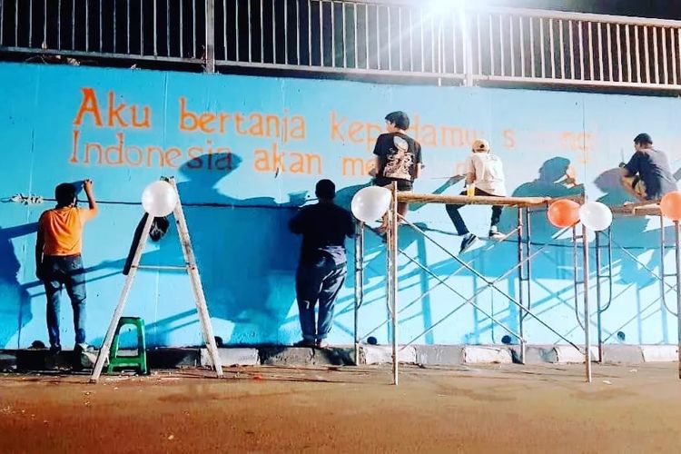 Para seniman yang tergabung dalam kelompok kolektif Jakarta Art Movement sedang melukis Mural Ketahanan Pangan di Flyover Klender.