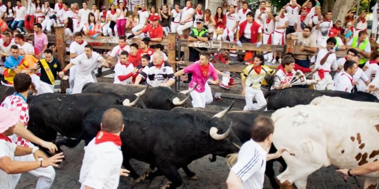 Festival Saint Fermin di Pamplona, Spanyol. Di festival ini, peserta dikejar banteng yang berlari di antara jalanan kota Pamplona.