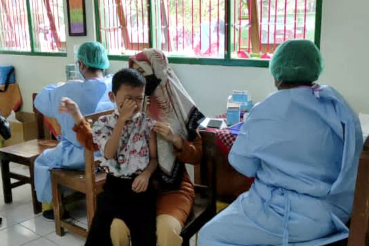 Seorang siswa SDN Sananwetan 2, Kota Blitar menangis saat hendak disuntik vaksin Covid-19 dosis kedua, Rabu (19/1/2022)