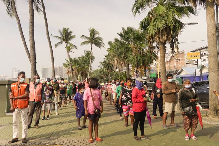Antrean panjang untuk mendapatkan bantuan makanan di salah satu pantai utama di Pattaya.