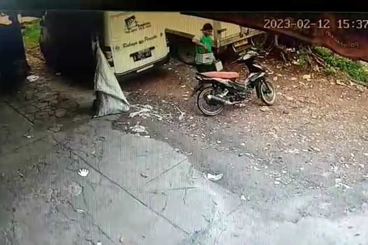 Seorang pria menggondol dua buah aki dari truk boks sebuah usaha logistik di kawasan Pusat Industri Kecil (PIK) Blok B, Kelurahan Penggilingan, Kecamatan Cakung, Jakarta Timur, pada Minggu (12/2/2023).