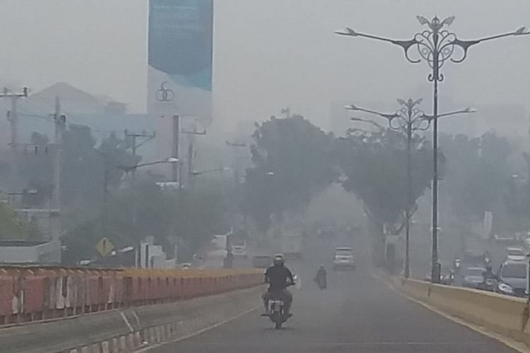 Kabut asap pekat dengan jarak pandang sekitar 300 meter di Jalan Jenderal Sudirman, Kota Pekanbaru, Riau, Jumat (13/9/2019).