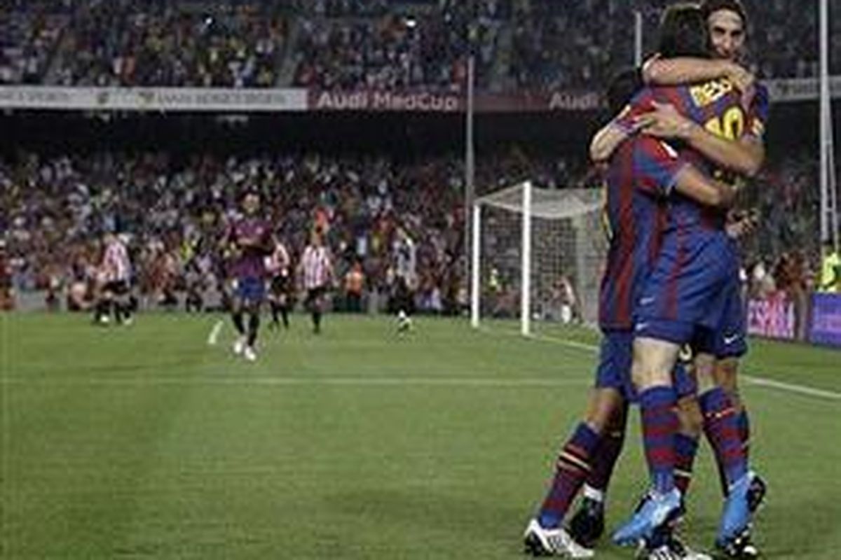 Lionel Messi dipeluk Zlatan Ibrahimovic dan Xavi Hernandez setelah dua kali membobol gawang Athletic Bilbao. Barcelona akhirnya juara Piala Super Spanyol.