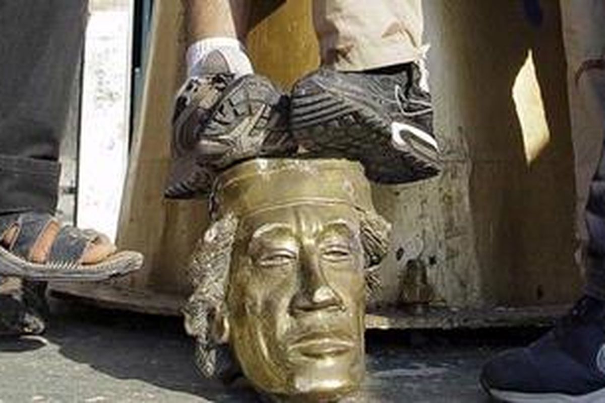 Para pemberontak  menginjak-injak patung  Khadafy, Selasa (23/8/2011), saat mereka berteriak-teriak bahwa mereka akan menemukan diktator yang telah berkuasa selama 42 tahun itu.