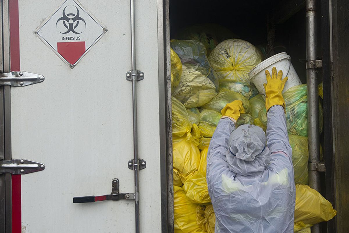 Petugas memindahkan kantong-kantong berisi limbah masker masyarakat dari truk milik Dinas Lingkungan Hidup (DLH) DKI Jakarta ke truk milik PT Wastec Internasional di Dipo Sampah Ancol, Jakarta, Rabu (15/7/2020). DLH DKI Jakarta bekerja sama dengan PT Wastec sebagai pihak ketiga untuk memusnahkan sampah masker dari masyarakat yang berpotensi masuk dalam kategori limbah bahan beracun berbahaya (limbah B3) sebagai upaya mencegah penyebaran COVID-19.